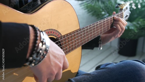close-up of guitar strings and fingerboard, guitarist plays flamenco on acoustic guitar