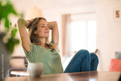 Woman sitting at dining table at home relaxing photo