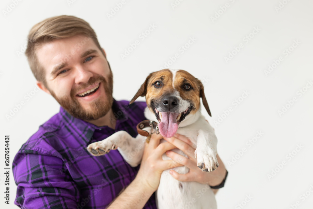 People and pet concept - Happy man holding a dog Jack Russell Terrier over the white background