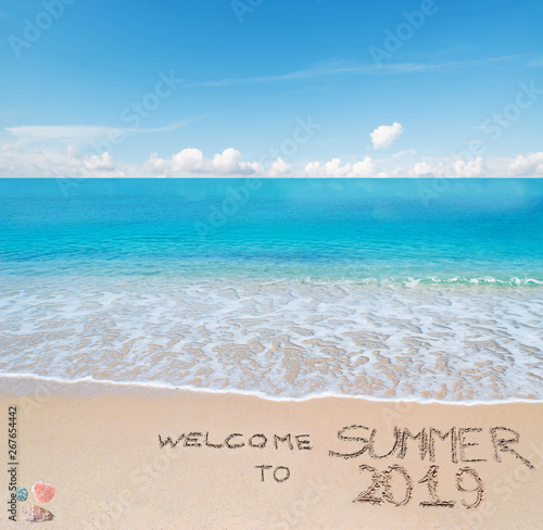welcome to summer 2019 written on a tropical beach