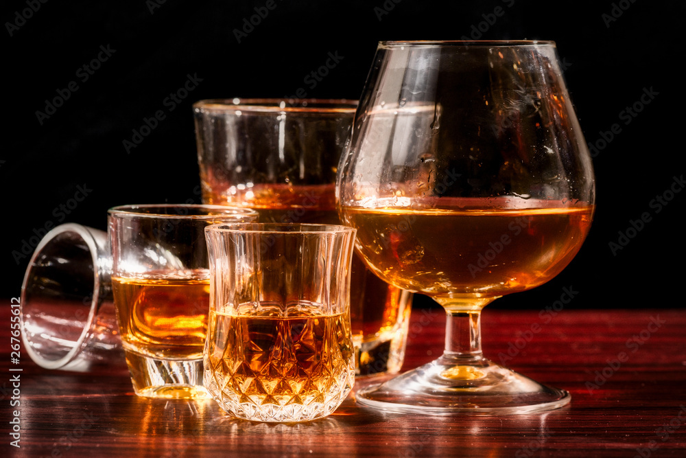 Brandy or liquor,Set of strong alcoholic drinks in glasses and shot glass on dark wood background Brandy or liquor,Set of strong alcoholic drinks in glasses and shot glass on dark wood background