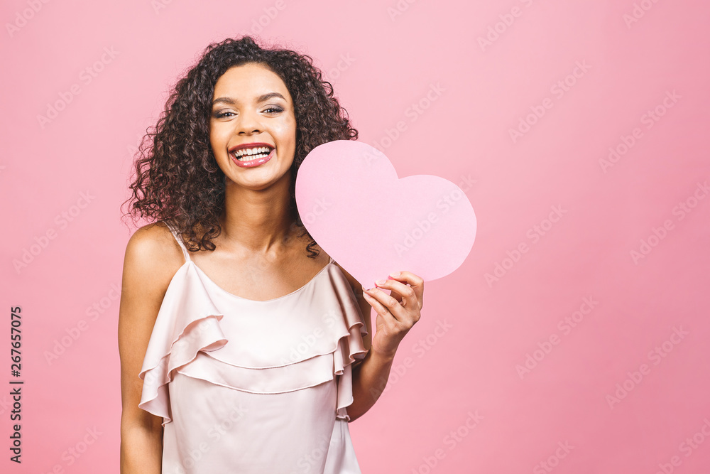 Portrait of attractive happy smiling american afro woman isolated against pink background with big pink heart. Portrait of attractive happy smiling american afro woman isolated against pink background with big pink heart.