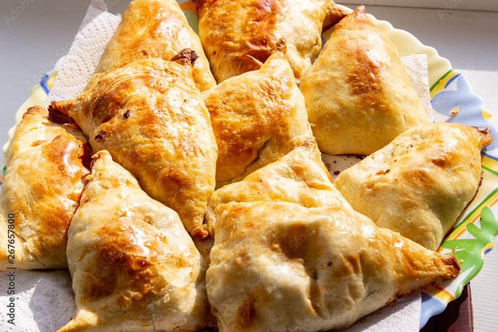 Bowl with delicious samosas on light background Bowl with delicious samosas on light background