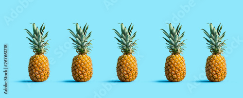 Many pineapples on a solid color background