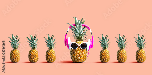 One out unique pineapple wearing headphones on a solid color background photo