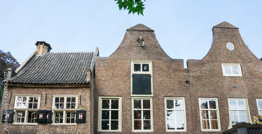 row gables of building with shutters in public park Stadhuistuin, Tiel, The Netherlands
