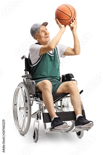 Senior disabled man holding a basketball and sitting in a wheelchair