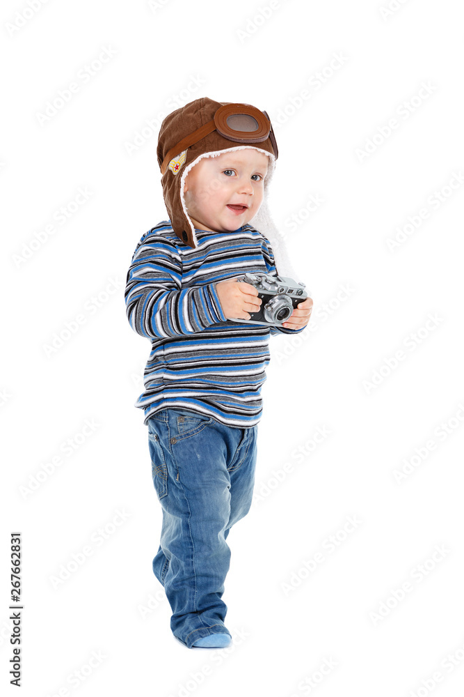 Smiling little Kid boy dressed in jeans, t-shirt and aviator helmet with photocamera in hands. Isolated on white background Smiling little Kid boy dressed in jeans, t-shirt and aviator helmet with photocamera in hands. Isolated on white background