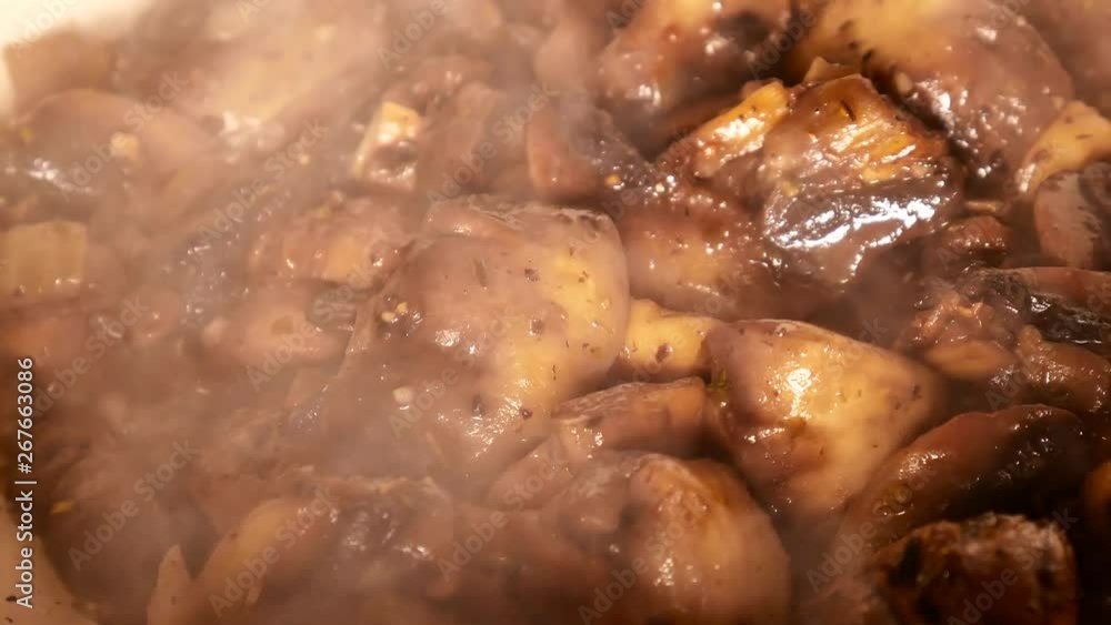 Champignon Mushrooms with onion are fried on frying pan with butter and olive oil. Extreme close-up. A lot of steam. Cooking in the kitchen food concept. Fried mushrooms with Golden crust and spices. Champignon Mushrooms with onion are fried on frying pan with butter and olive oil. Extreme close-up. A lot of steam. Cooking in the kitchen food concept. Fried mushrooms with Golden crust and spices.