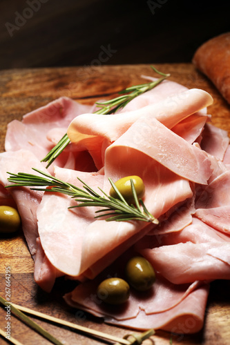 Sliced ham on wooden background. Fresh prosciutto cotto. Pork ham sliced with herbs photo