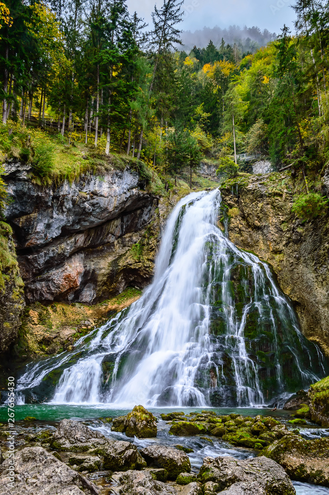 Gollinger Waterfall in Golling an der Salzach near Salzburg, Austria. Stunning view of cascade waterfall over mossy rocks in the Alps with long exposure