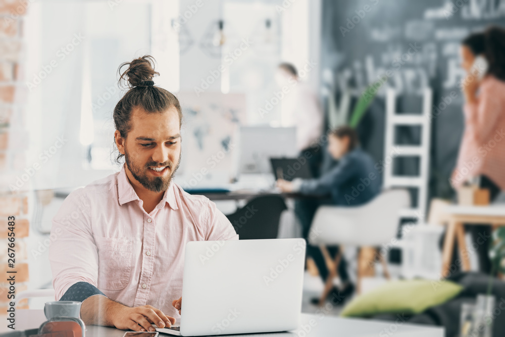 Happy and creative businessman using laptop while working in international company Happy and creative businessman using laptop while working in international company