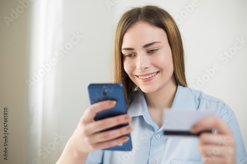 Online payment. Young woman using a credit card and smart phone for online shopping. 