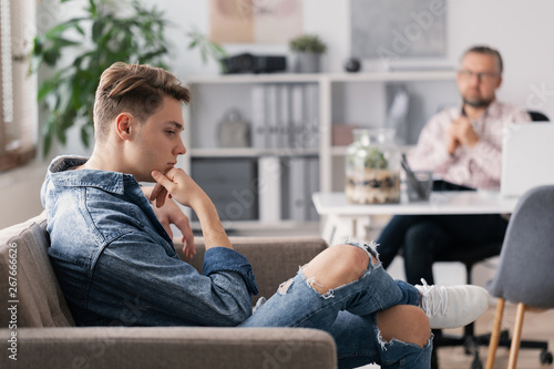 Foto Professional therapist and teenage boy ignoring him during appointed meeting