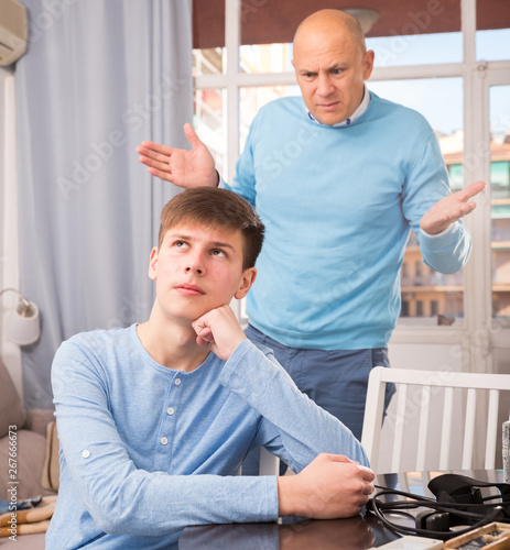 Man scolding son at home