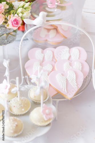 Sweet table at Christening or First Communion party. Heart shaped cookies with angel wings.