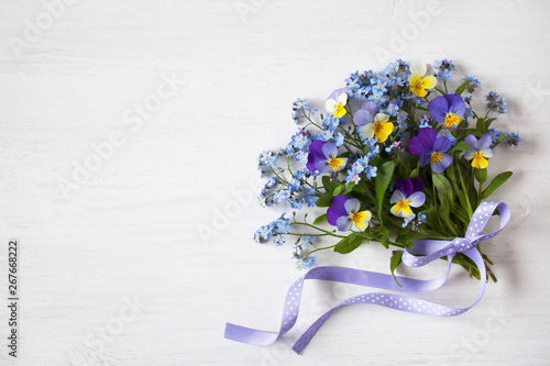 Fényképezés A bouquet of forget-me-nots and pansies on a wooden background