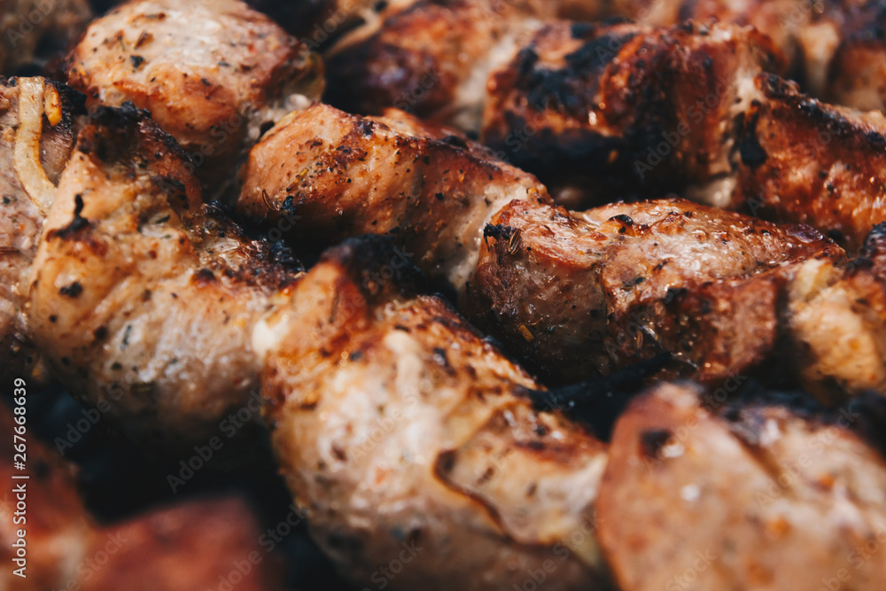 Closeup of some meat skewers being grilled in a barbecue