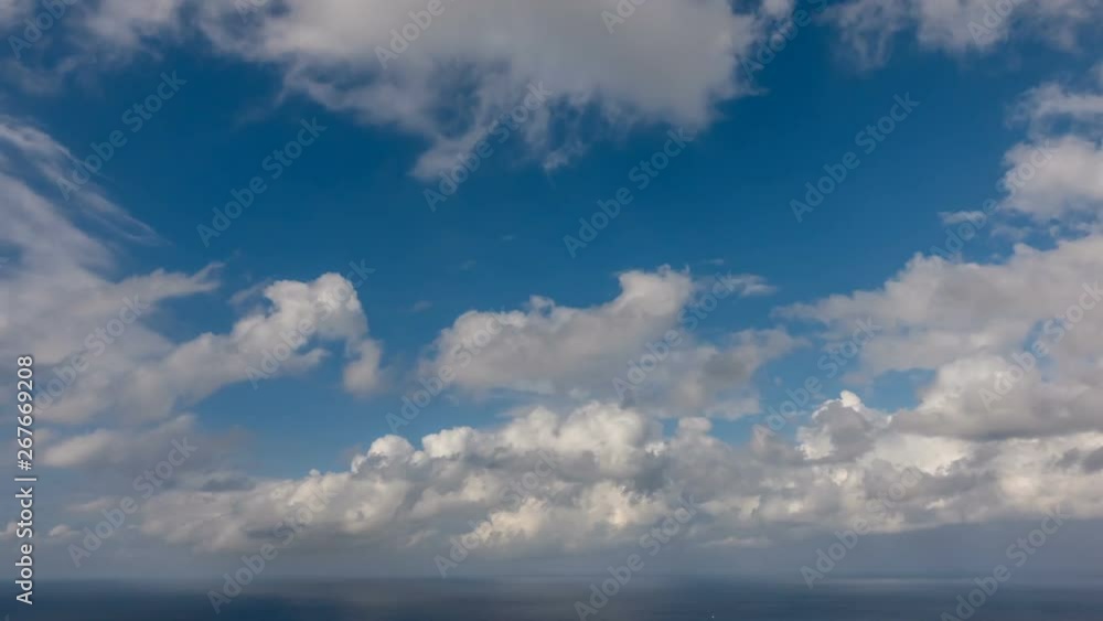 HD Time lapse of white summer clouds over ocean horizon Cloud running across the blue sky background HD Time lapse of white summer clouds over ocean horizon Cloud running across the blue sky background