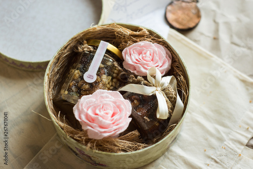  gift box with farm honey and decorated of gantle pink flowers on the rustic background photo