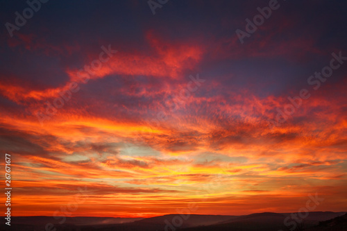 Gorgeous orange sunset colorful clouds in evening sky, natural beauty of nature © okostia