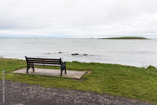 Empty bench facing the ocean on an overcast winter day