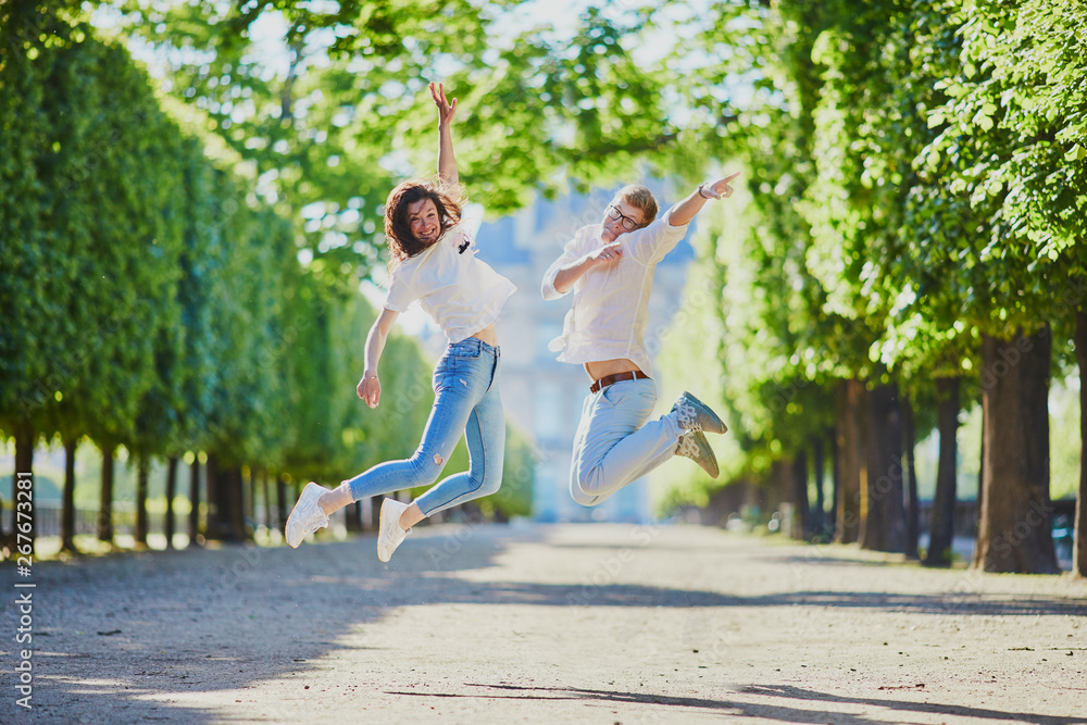 Happy romantic couple in Paris, jumping in Tuileries garden