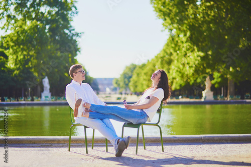 Happy romantic couple in Paris, sitting on traditional green metal chairs in Tuileries garden © Ekaterina Pokrovsky