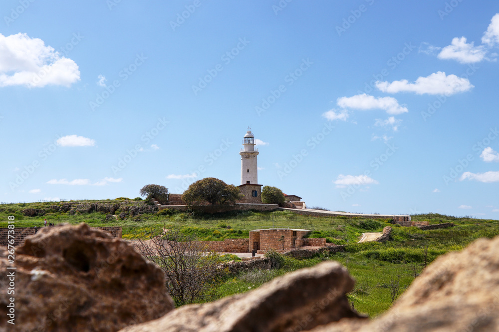 Historical Paphos lighthouse set in the middle of archaeological park in Paphos, Cyprus. View on Pafos landscape with beautiful white beacon and with clear sky