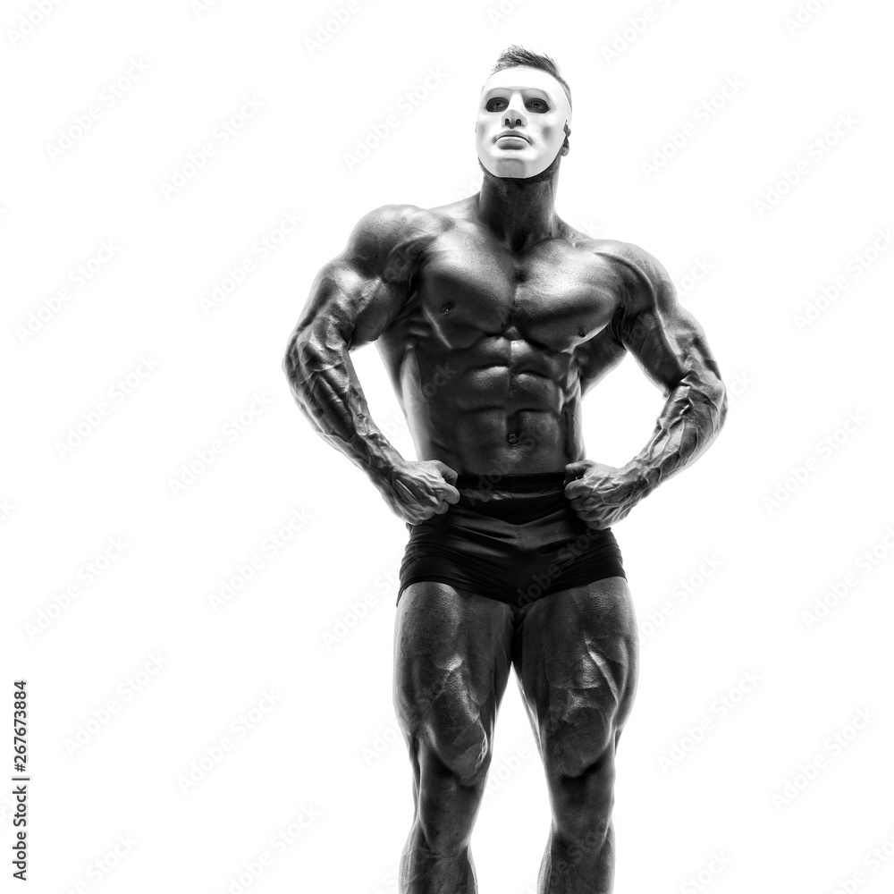 Mysterious Muscular man hiding behind white mask. Bodybuilder with white mask on his face. Studio shot on white background Mysterious Muscular man hiding behind white mask. Bodybuilder with white mask on his face. Studio shot on white background