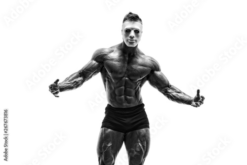 Mysterious Muscular man hiding behind white mask. Bodybuilder with white mask on his face. Studio shot on white background