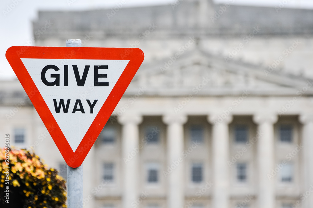 Give Way traffic road sign outside Parliament Buildings, Stormont Estate symbolising negotiation and compromise between political parties.