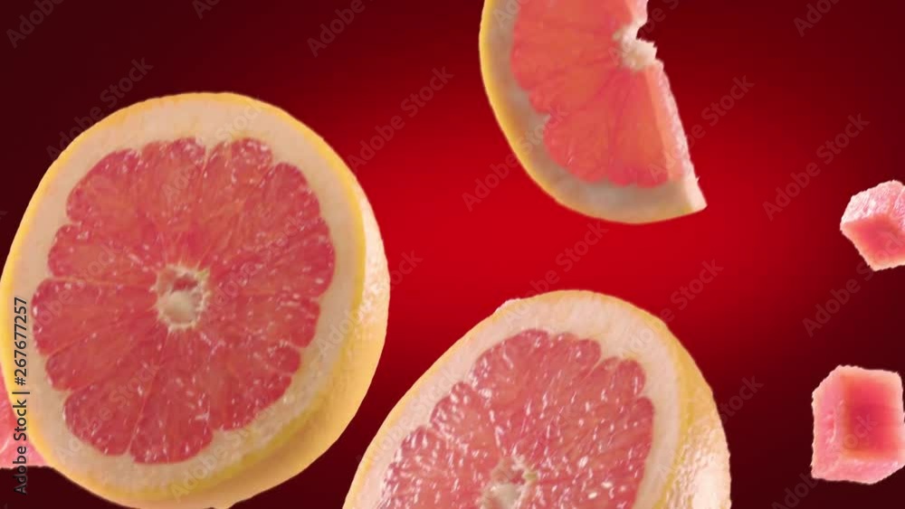 Grapefruit with Slices Falling on Deep Red Background Grapefruit with Slices Falling on Deep Red Background