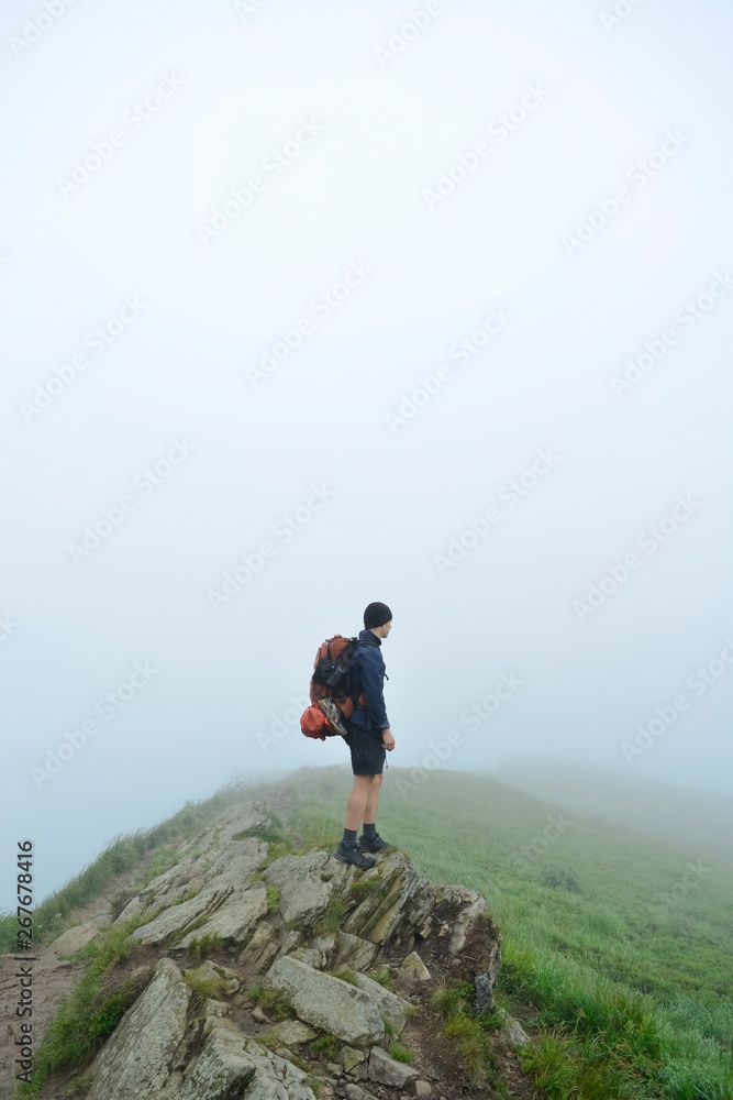 The young guy on the top of the mountain. Bieszczady Mountains, Poland. Travel concept.	