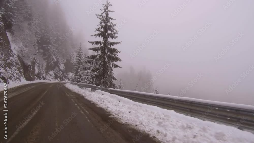 Snow piled against guardrails. Beautiful winter landscape with trees and ground covered in fresh white snow. Dangerous road conditions driving on a winding mountain road. Snow piled against guardrails. Beautiful winter landscape with trees and ground covered in fresh white snow. Dangerous road conditions driving on a winding mountain road.