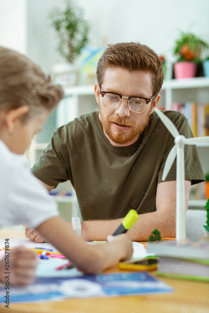 Focused good-looking ginger teacher working on poster Focused good-looking ginger teacher working on poster