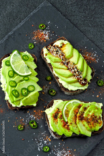Avocado toasts on a stone board.