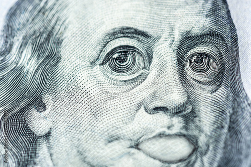 Big eyes of Benjamin Franklin with a hundred dollar bill, a symbol of inflation, appreciation, devaluation, close-up © Алексей Еремеев