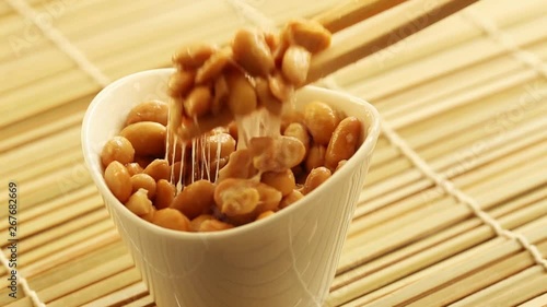 Eating healthy traditional japanese fermented soybeans called natto with chopsticks photo