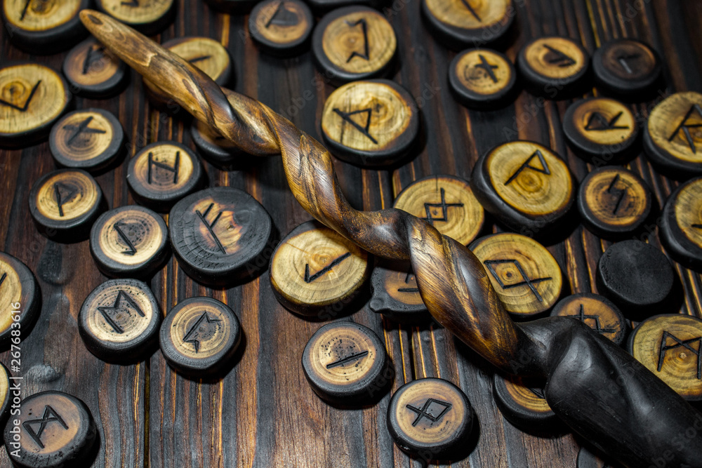 Homemade magic wands and wooden runes on a dark wooden background Homemade magic wands and wooden runes on a dark wooden background