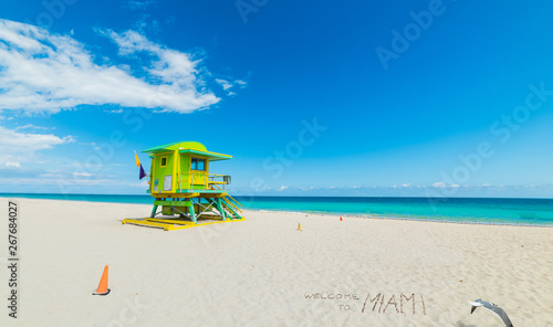 Welcome to Miami written by a colorful lifeguard tower in Miami Beach