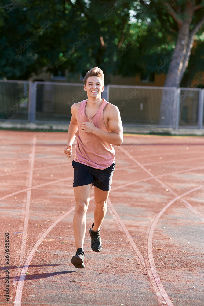 Obraz premium Young muscular man running on the track