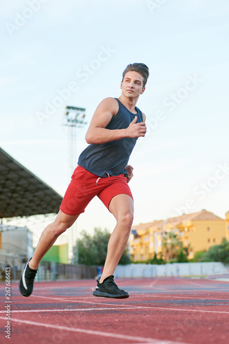 Young muscular man running on the track © bodiaphoto