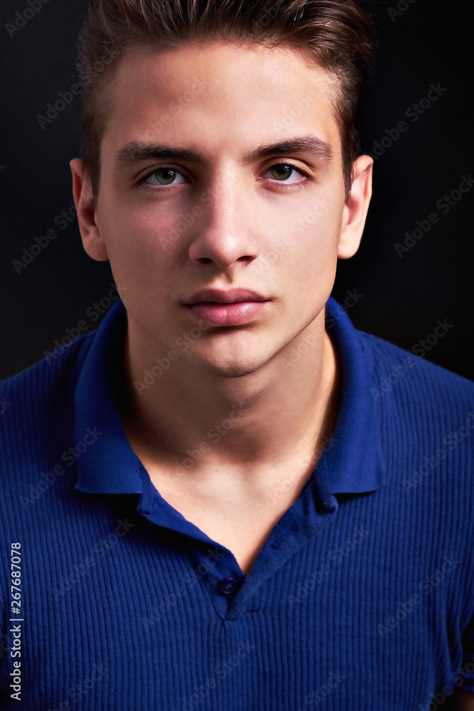 Elegant young handsome man posing on black background