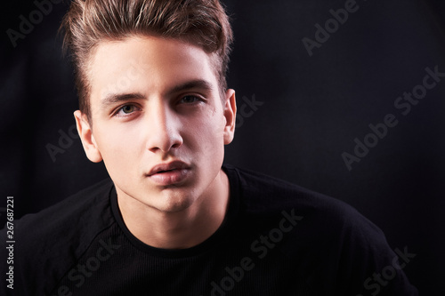 Fashion portrait of elegant young handsome man isolated on black background