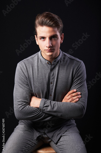 Fashion portrait of elegant young handsome man isolated on black background