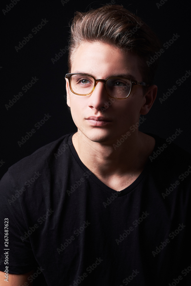Portrait of elegant young handsome man isolated on black background Portrait of elegant young handsome man isolated on black background
