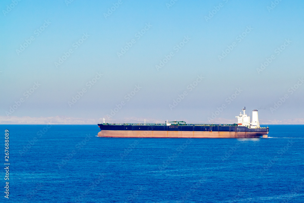Barge or oil tanker in a calm sea on the horizon