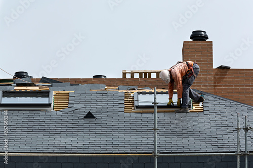 Obrero trabajando en el tejado de pizarra de un edificio. photo