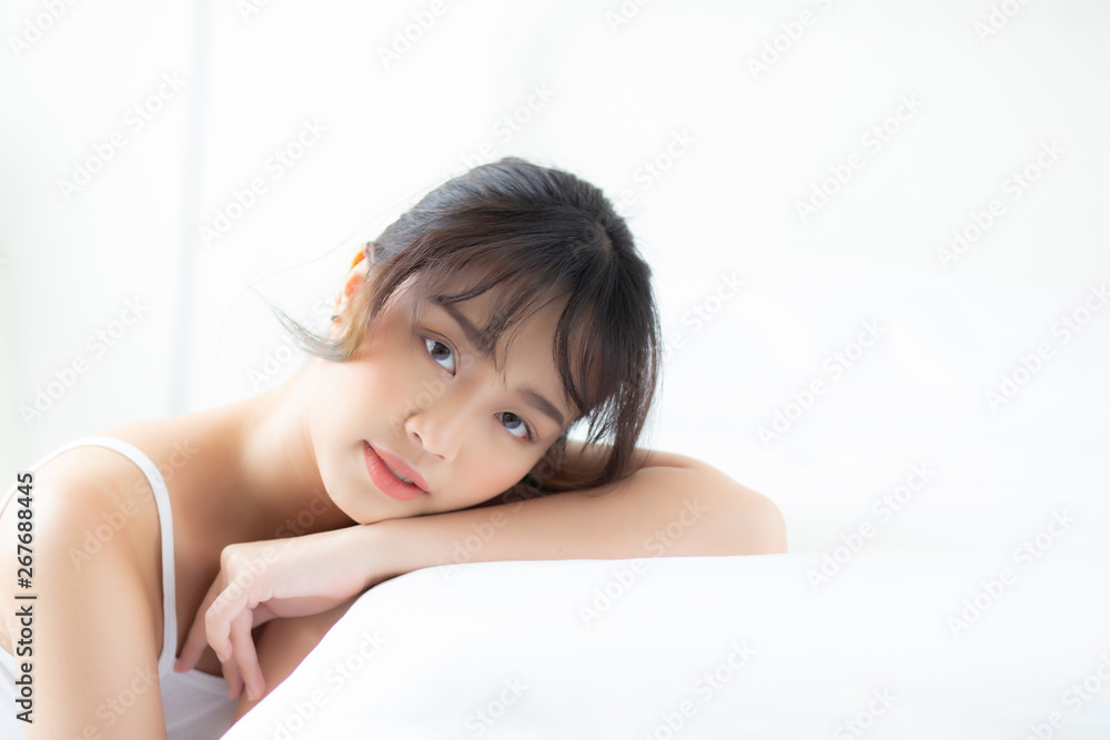 Lifestyle beautiful portrait young asian woman relax lying sleep and smile while wake up with sunrise at morning, girl with happy and fun in the bedroom, health and wellness concept. Lifestyle beautiful portrait young asian woman relax lying sleep and smile while wake up with sunrise at morning, girl with happy and fun in the bedroom, health and wellness concept.